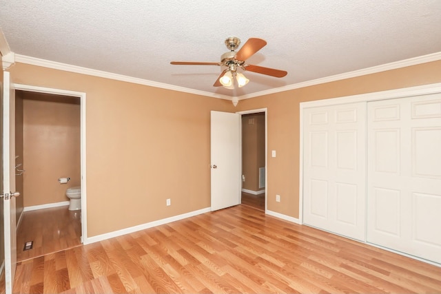 unfurnished bedroom with ceiling fan, light wood-type flooring, ornamental molding, and a textured ceiling