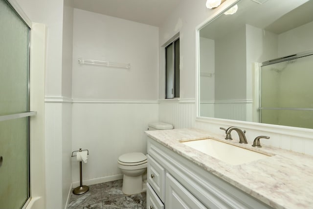 bathroom featuring an enclosed shower, vanity, and toilet