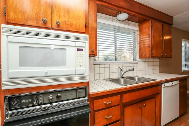 kitchen featuring white appliances, tasteful backsplash, tile counters, and sink