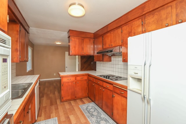 kitchen featuring tasteful backsplash, tile counters, white refrigerator with ice dispenser, and electric stovetop