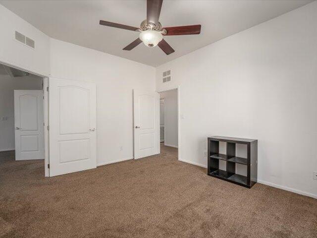 unfurnished bedroom featuring ceiling fan and carpet floors