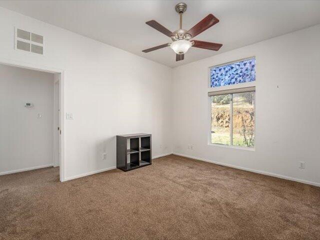 empty room featuring carpet and ceiling fan