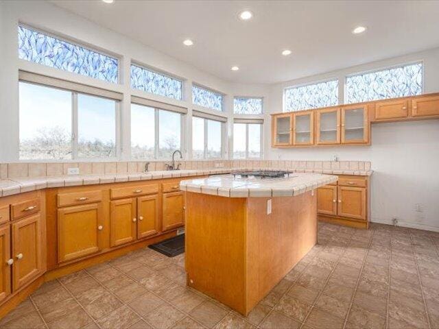 kitchen featuring tile countertops, a kitchen island, and sink