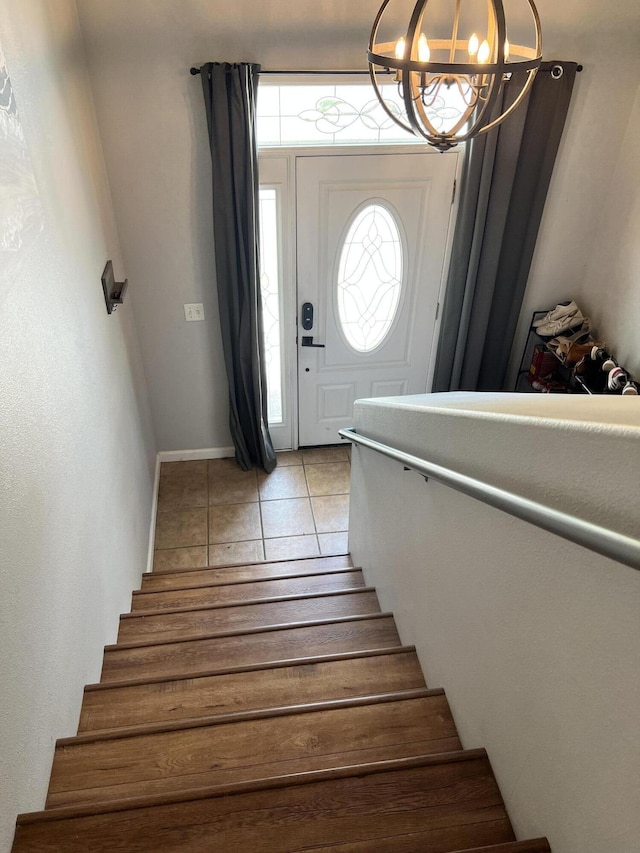 staircase featuring tile patterned flooring and an inviting chandelier