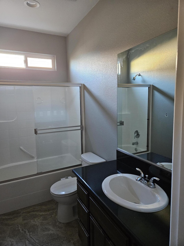 full bathroom featuring shower / bath combination with glass door, vanity, and toilet