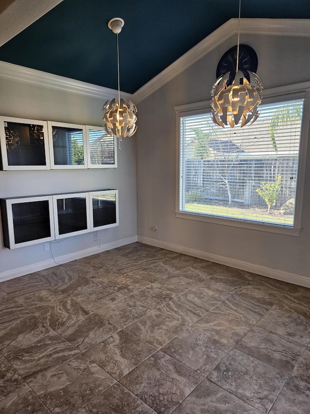 unfurnished dining area with plenty of natural light, vaulted ceiling, ornamental molding, and a chandelier