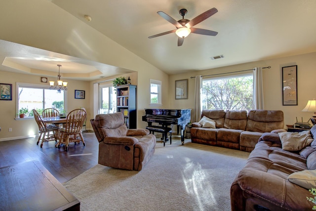 living room featuring lofted ceiling, a tray ceiling, a wealth of natural light, and dark hardwood / wood-style floors