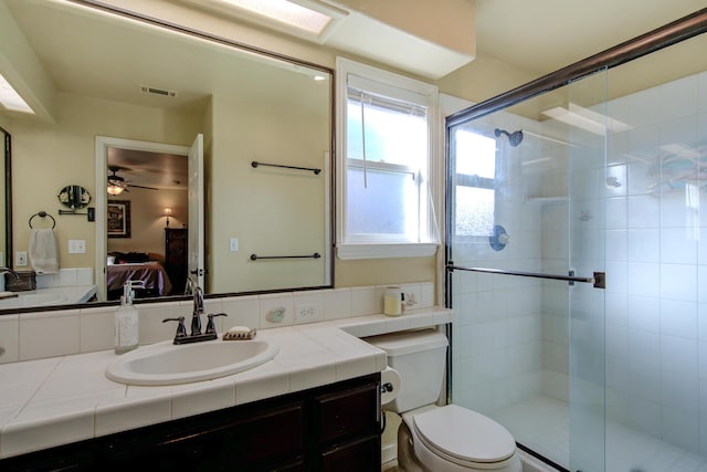 bathroom with walk in shower, vanity, and toilet