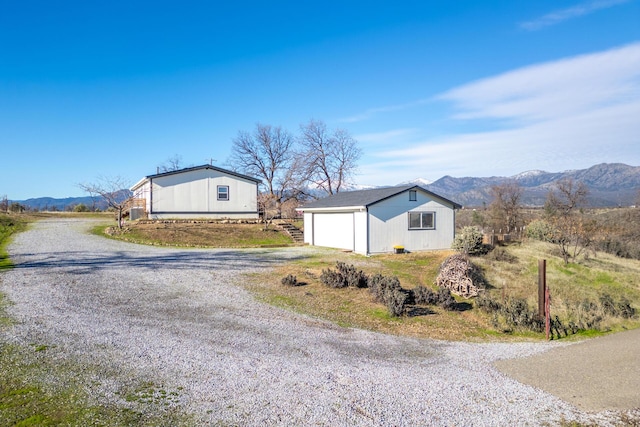 exterior space featuring a mountain view, an outbuilding, and a garage