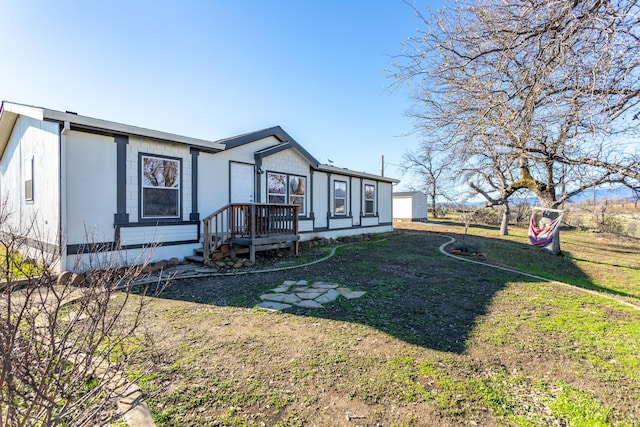 view of front facade featuring a garage, an outdoor structure, and a front lawn