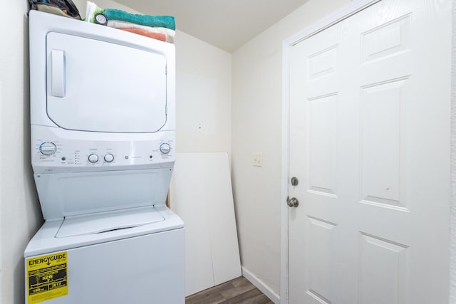 clothes washing area with hardwood / wood-style floors and stacked washer and dryer