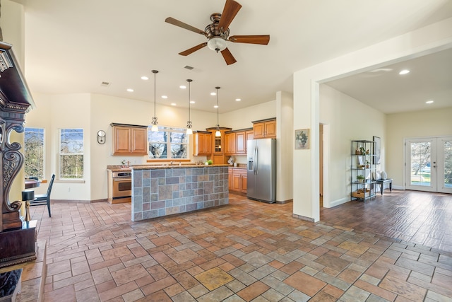 kitchen featuring ceiling fan, a kitchen island, a wealth of natural light, and appliances with stainless steel finishes