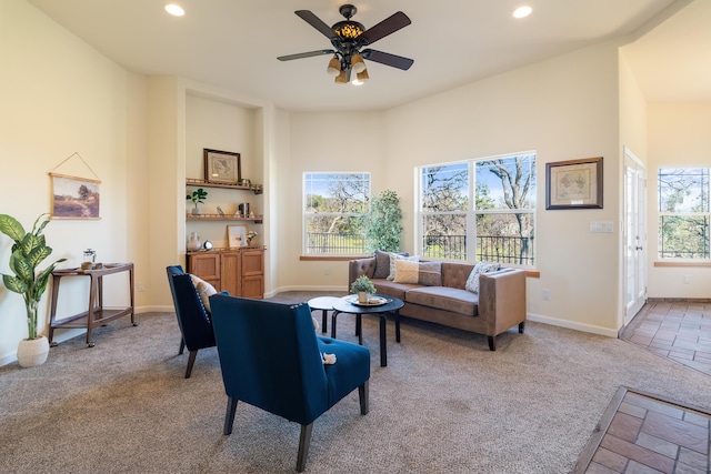 carpeted living room with ceiling fan