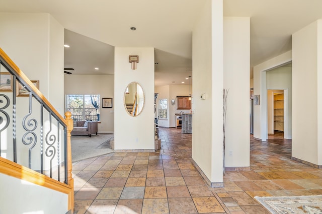 carpeted foyer with ceiling fan