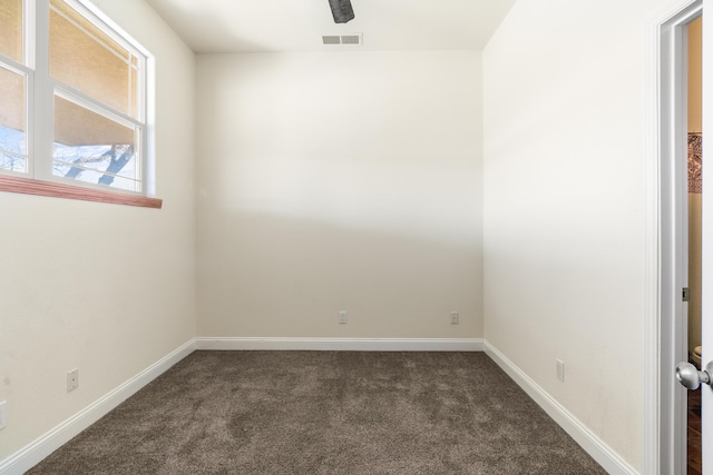 unfurnished room with dark colored carpet