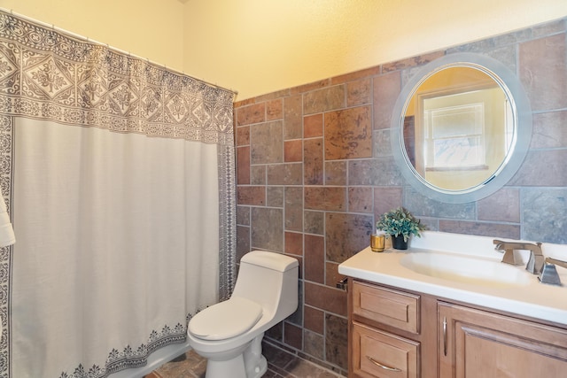 bathroom with vanity, curtained shower, toilet, and tile walls