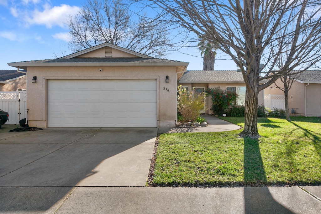 ranch-style house with a front yard and a garage