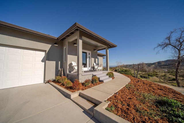 exterior space featuring a mountain view, a porch, and a garage