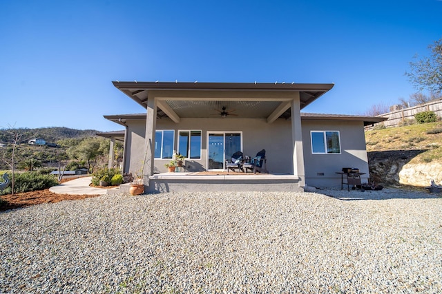 rear view of property featuring ceiling fan and a patio