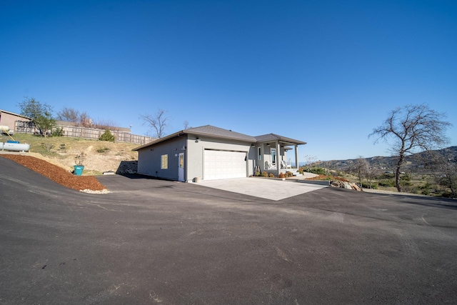 view of front of house featuring a mountain view, a porch, and a garage