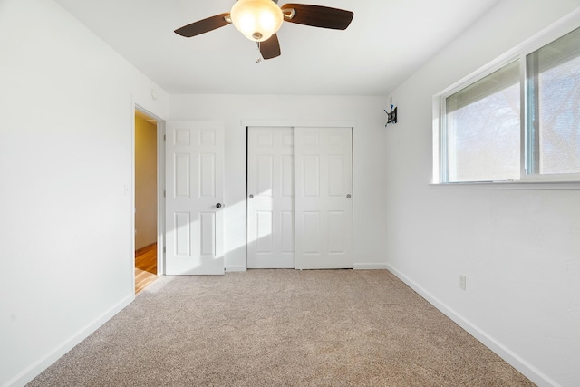 unfurnished bedroom with carpet, ceiling fan, and a closet