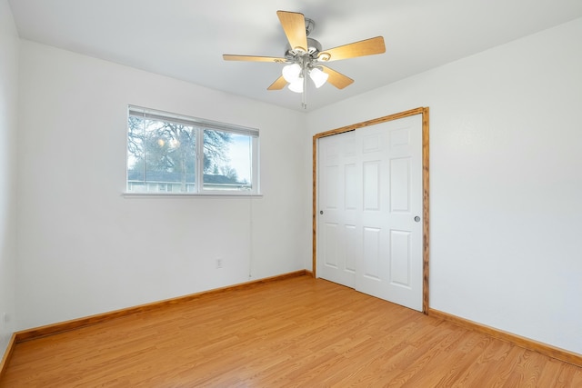 unfurnished bedroom featuring a closet, light hardwood / wood-style floors, and ceiling fan