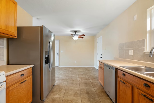 kitchen with sink, ceiling fan, light tile patterned floors, tasteful backsplash, and stainless steel appliances