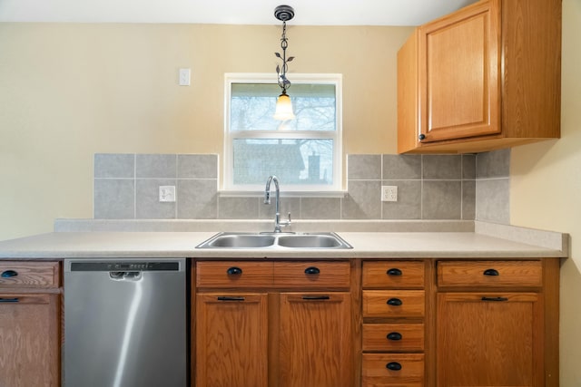 kitchen featuring pendant lighting, dishwasher, backsplash, and sink