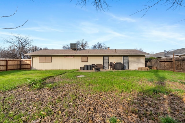 rear view of property with a lawn and central AC