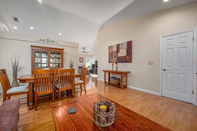 dining space featuring ceiling fan, vaulted ceiling, and light hardwood / wood-style flooring