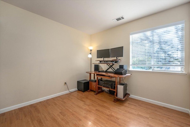 home office with light hardwood / wood-style floors