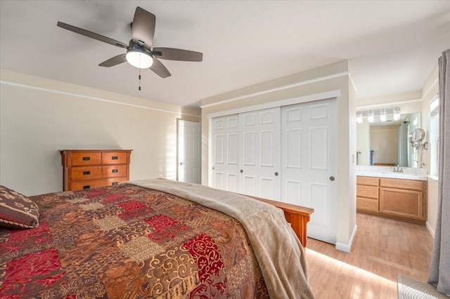 bedroom with sink, connected bathroom, ceiling fan, light hardwood / wood-style floors, and a closet