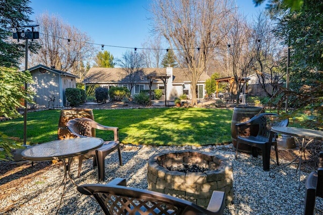 view of yard featuring an outdoor fire pit and a shed