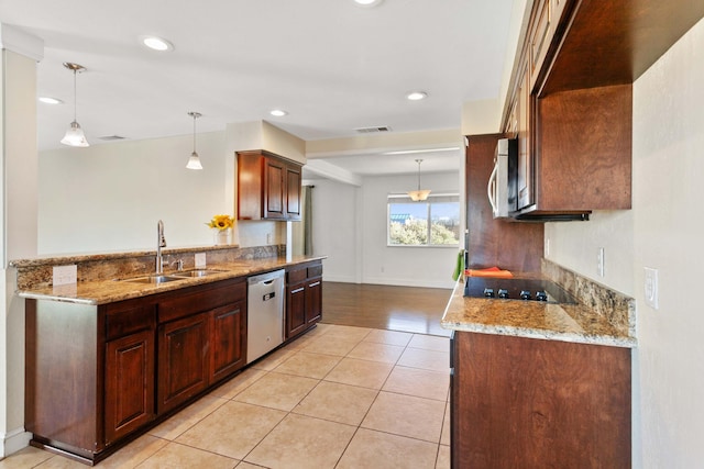 kitchen with pendant lighting, sink, appliances with stainless steel finishes, light tile patterned flooring, and light stone counters