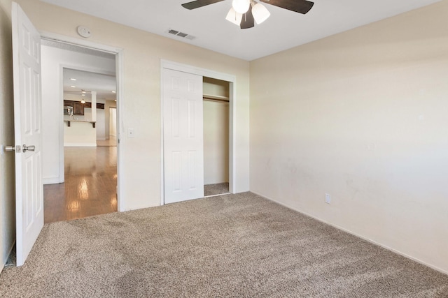 unfurnished bedroom featuring ceiling fan, a closet, and carpet