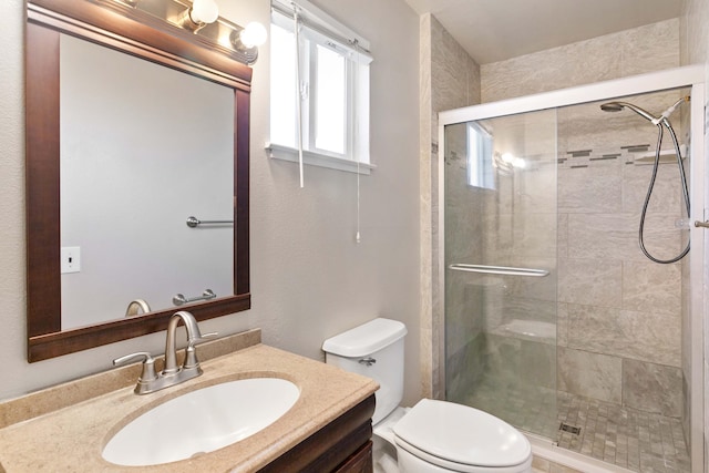 bathroom featuring vanity, toilet, and walk in shower