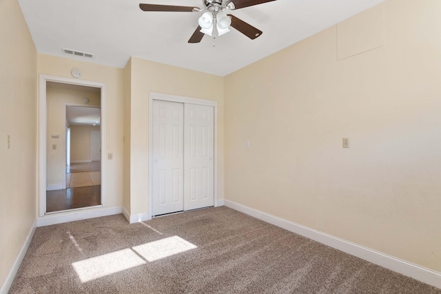 unfurnished bedroom with ceiling fan, a closet, and carpet floors