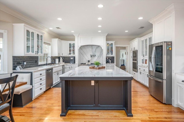 kitchen featuring white cabinetry, a center island, stainless steel appliances, and tasteful backsplash