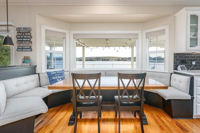 dining area featuring a water view, light hardwood / wood-style flooring, and breakfast area