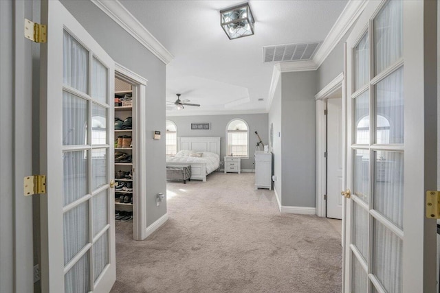 hallway featuring light carpet, ornamental molding, and french doors