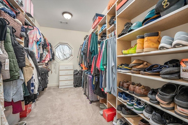 walk in closet featuring light colored carpet