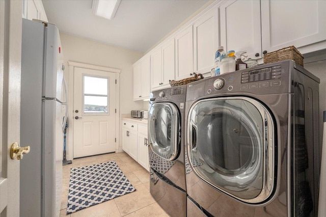 laundry room with cabinets, light tile patterned floors, and independent washer and dryer