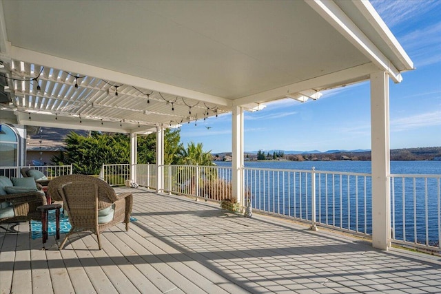 wooden terrace featuring a water view and a pergola