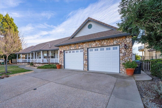 ranch-style home with a porch and a garage