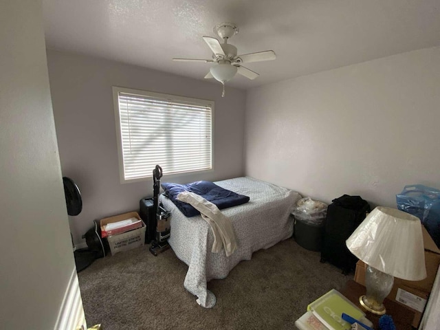 bedroom with ceiling fan and dark carpet