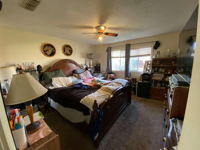 bedroom with ceiling fan, a textured ceiling, and dark colored carpet