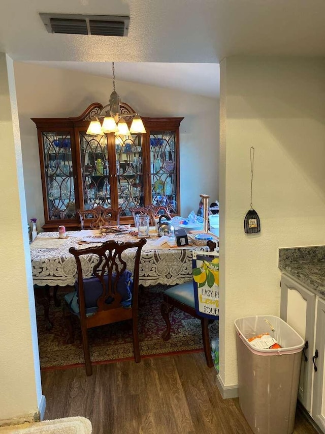 dining room with dark hardwood / wood-style floors and a chandelier