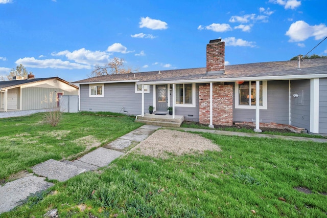 single story home featuring a garage, an outdoor structure, and a front yard