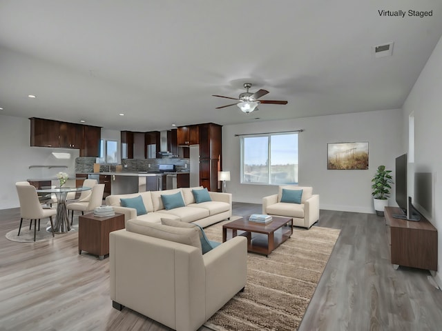 living room featuring light wood-type flooring and ceiling fan