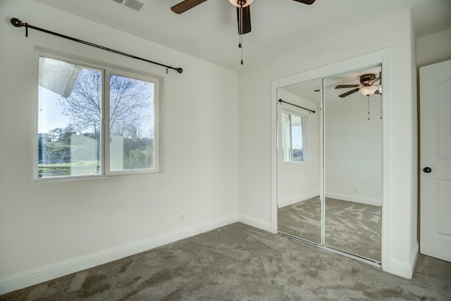 unfurnished bedroom featuring multiple windows, ceiling fan, a closet, and carpet floors